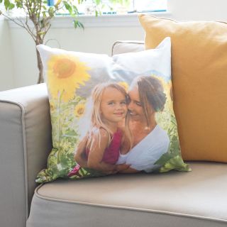 A pillow personalized with a photo of a woman holding a girl on her lap.