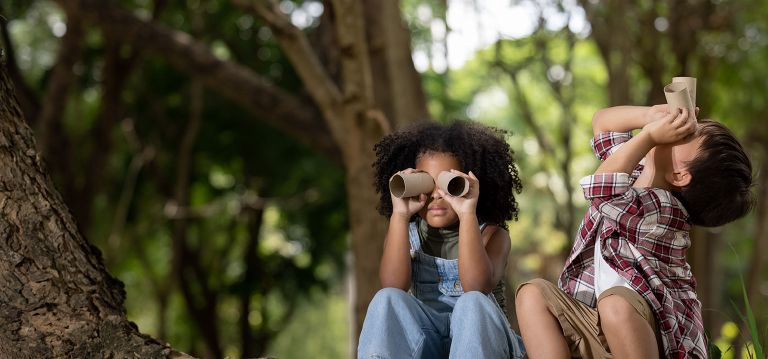 A picture of two children playing pretending they are looking through binoculars