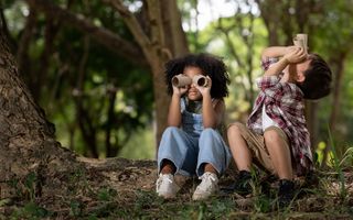 A picture of two children playing pretending they are looking through binoculars