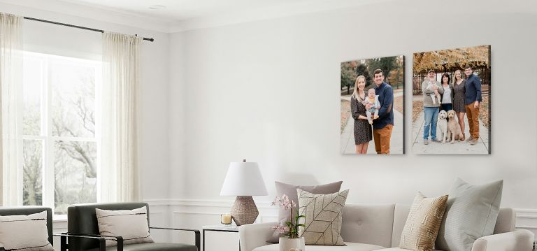 two canvas prints of a family sitting above a modern couch living room setting