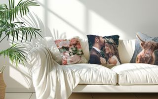 A white couch with some pillows, focusing on one personalized with a couple on their wedding day.